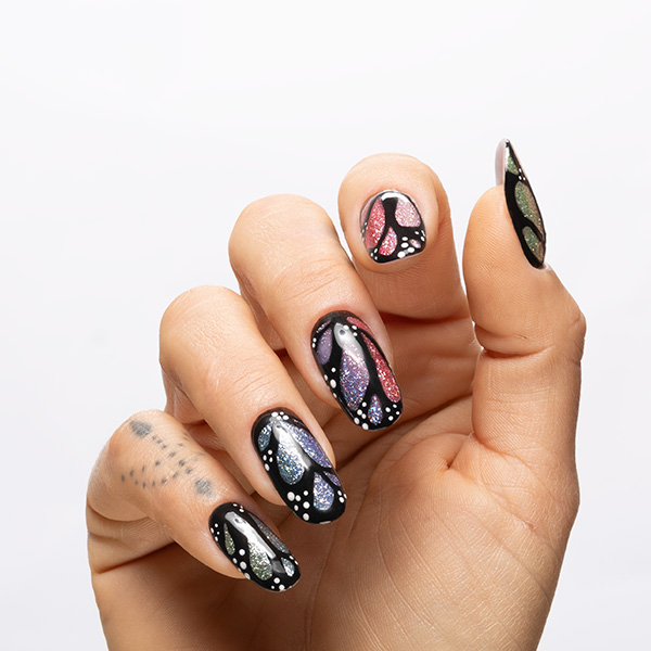 Nail art nera con riflessi galaxy e dettagli graphic